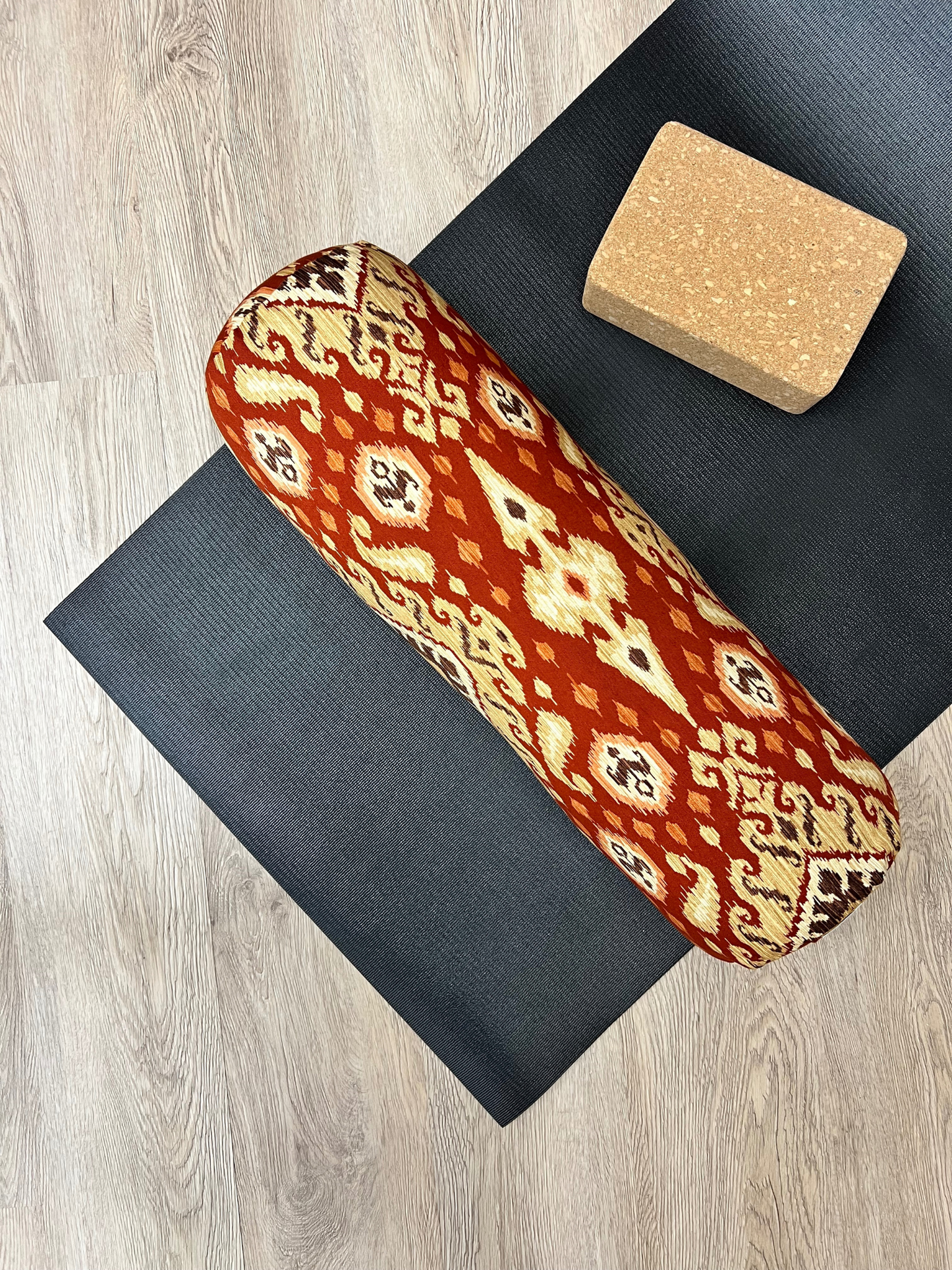 Round yoga bolster in Red and Gold Ikat Print. Cotton canvas removeable cover. Handcrafted in Calgary Alberta Canada