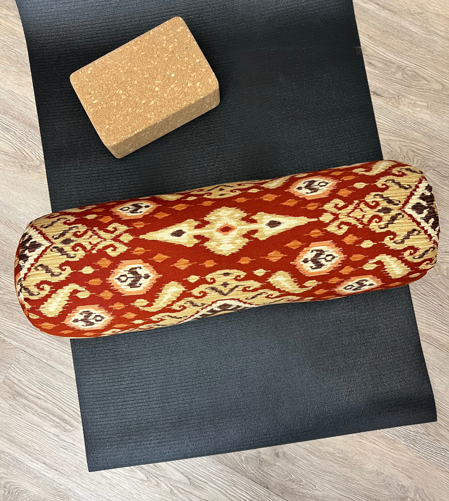 Round yoga bolster in Red and Gold Ikat Print. Cotton canvas removeable cover. Handcrafted in Calgary Alberta Canada